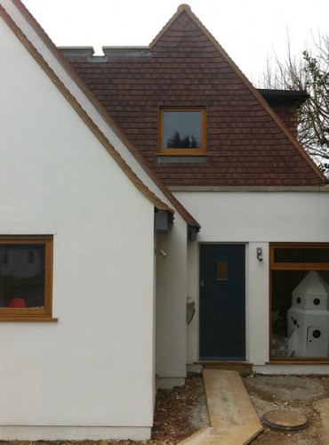 side extension replaces derelict garage with relocated front door